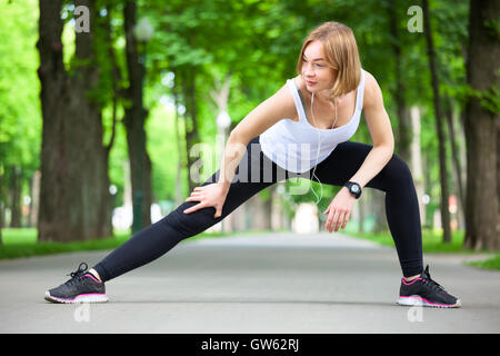 Young beautiful woman stretching in the park. Stock Photo