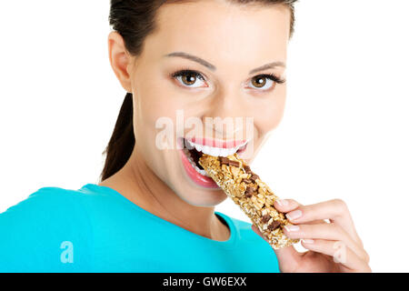 Young woman eating cereal candy bar Stock Photo