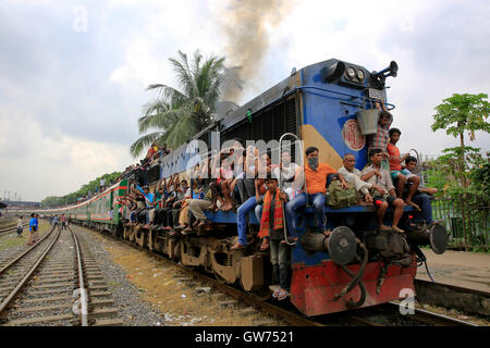 Dhaka, Bangladesh. 12 September, 2016: People leaving Dhaka to celebrate the Eid vacation travel on the train roof at the Airport Railway Station. Stock Photo