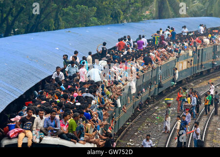 Dhaka, Bangladesh. 12 September, 2016: People leaving Dhaka to celebrate the Eid vacation travel on the train roof at the Airport Railway Station. Stock Photo