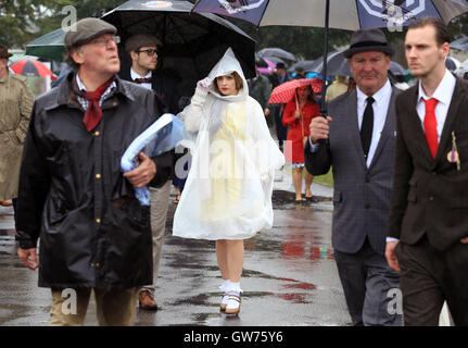Visitors pictured in the bad weather, whilst in period dress at the Goodwood Revival this morning. Stock Photo