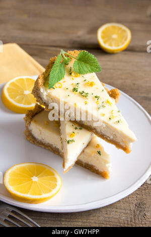Pieces of delicious homemade lemon cheesecake on plate close up Stock Photo