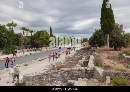 Tourists walking down the main road of the resort town of Side, surrounded by ancient ruins. Side, Turkey. Stock Photo