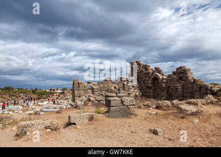 Tourists visiting the ancient ruins in of the state agora. Side, Turkey. Stock Photo