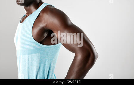Cropped shot of young african man muscular arms against grey background. Stock Photo
