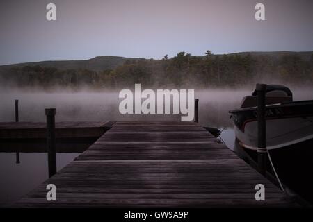 A misty morning on Twin Lakes in Salisbury, Connecticut with the Berkshire mountains in the distance. Stock Photo