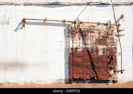 Warehouse style sliding door on a partially ruined building. Stock Photo
