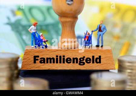 Miniature figures on a stamp with the label family money, Miniaturfiguren auf einem Stempel mit der Aufschrift Familiengeld Stock Photo