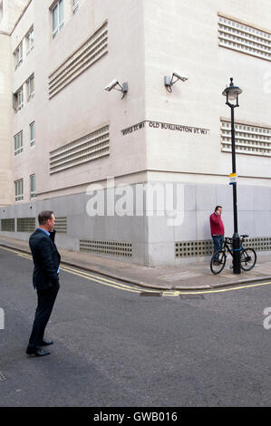 Two strangers being watched by surveillance cameras, Old Burlington Street, London Stock Photo