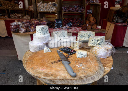 Cheese stall in market in Mont-De-Lans, Alps, France with a selection of cheeses and dry sausage Stock Photo