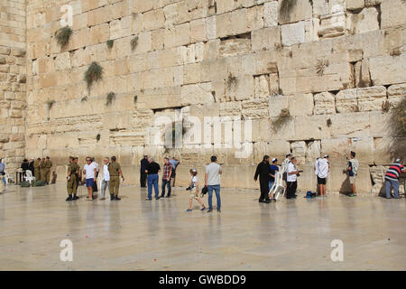 Jewish  soldiers, along with other worshipers praying at the mens side of the Western Wailing Wall which is also known as Kotel Stock Photo