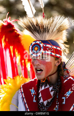 A Native American dancer from the Arapahoe people dressed in traditional costume prepares to perform a fancy dance at the Indian Village during Cheyenne Frontier Days July 25, 2015 in Cheyenne, Wyoming. Frontier Days celebrates the cowboy traditions of the west with a rodeo, parade and fair. Stock Photo