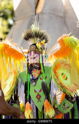 A Native American dancer from the Arapahoe people dressed in traditional costume at the Indian Village during Cheyenne Frontier Days July 25, 2015 in Cheyenne, Wyoming. Frontier Days celebrates the cowboy traditions of the west with a rodeo, parade and fair. Stock Photo