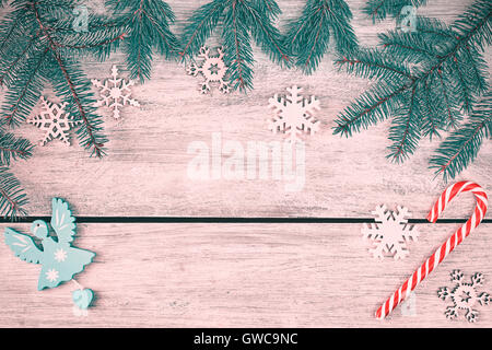 Retro stylized Christmas background, spruce branches with decorations on a rustic wooden table, top view with copy space. Stock Photo