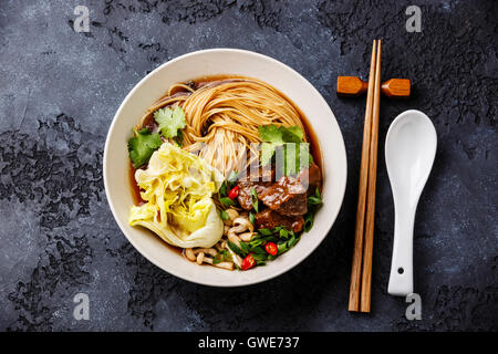 Spicy asian noodles in broth with Beef on dark background Stock Photo