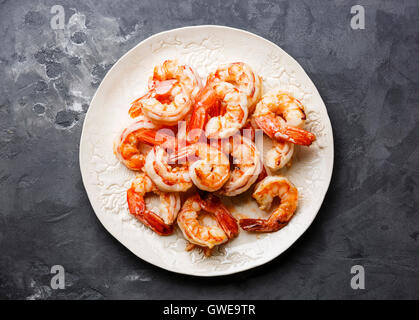 Roasted Prawns on white plate on gray concrete stone background Stock Photo