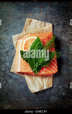 Raw salmon fillet and ingredients for cooking in a rustic style. Top view Stock Photo