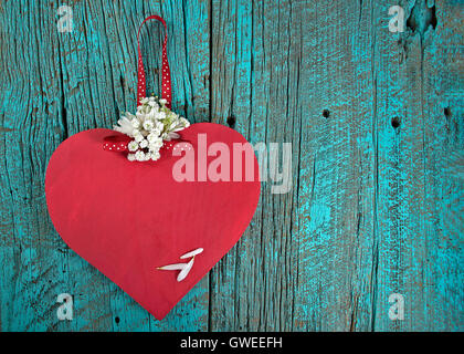 Red wooden heart and daisy bouquet on turquoise painted rustic wood Stock Photo