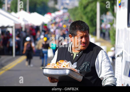 Quito, ECUADOR - JULY 07, 2015: Unidentified man selling sandwiches in Pope Francis mass. Street food is usually homemade and helps provide extra income for low class families Stock Photo