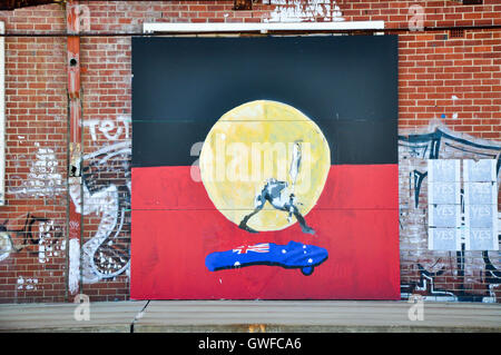 Mural art of aboriginal flag with human representation and Australian flag on outdoor brick wall in Fremantle,Western Australia. Stock Photo