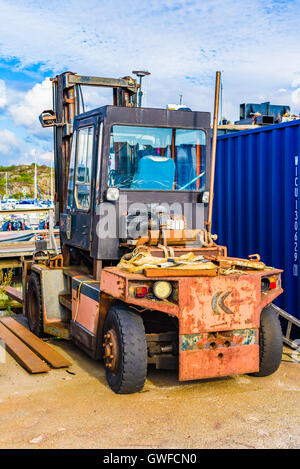 Marstrand, Sweden - September 8, 2016: Environmental documentary of old forklift parked beside a container in a marina. Stock Photo