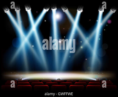 A theater or theatre stage and with footlights and spotlights and red audience seats in rows Stock Photo
