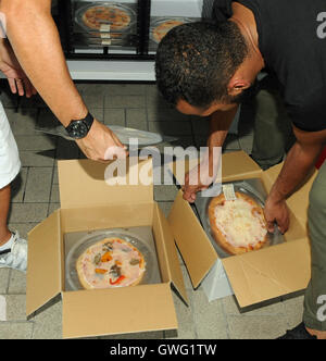 Lakeland, United States. 13th Sep, 2016.  Pizza Touch employees remove pizzas from boxes and load them into one of the company's vending machines outside a gas station in Lakeland, Florida on September 13, 2016. The company brought the concept from Italy and Portugal to the United States for the first time in July 2016, testing several machines in Orlando and Lakeland, Florida. Pepper and mushroom, margherita, and four cheese pizzas can be purchased for $6.00 each and are ready to eat in two minutes. Credit:  Paul Hennessy/Ģ����ý Live News Stock Photo