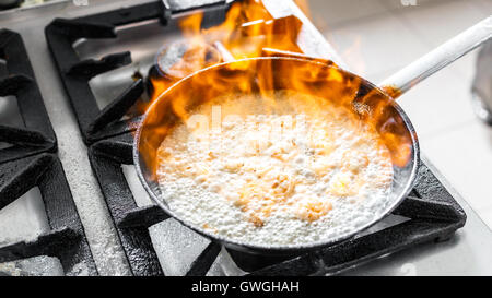 Chef cooking with fire in frying pan Stock Photo