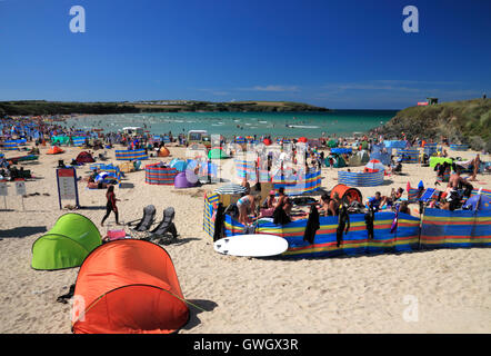 A beach crowded with holidaymakers and windbreaks at Harlyn Bay, North Cornwall. Stock Photo