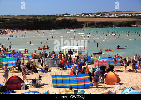 An ice-cream van on a beach crowded with holidaymakers and windbreaks at Harlyn Bay, North Cornwall. Stock Photo