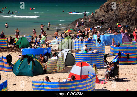 A beach crowded with holidaymakers and windbreaks at Harlyn Bay, North Cornwall. Stock Photo