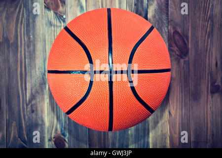 Basketball ball on wooden hardwood floor in the basketball court. Retro vintage picture. Sport concept. Stock Photo