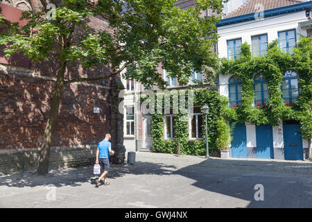 man walks with water bottles in old picturesque part in Patershol in centre of ghent in belgium Stock Photo