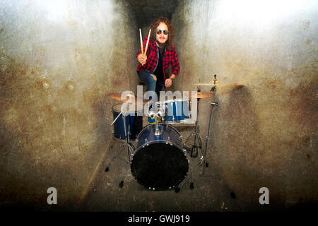 Drums conceptual image. Rock drummer holding drumsticks and playing on drums. Retro vintage grunge picture. Stock Photo