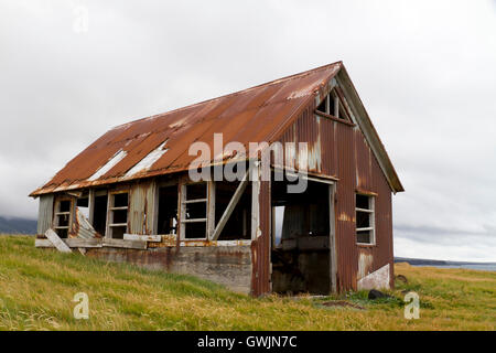 Run down old shed clad in rusty corrugated iron, situated on the coast Stock Photo