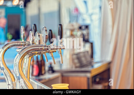 Draught beer taps and other beverages in a bar. Stock Photo