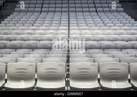 Many rows of empty plastic seats at a grandstand, viewed from the front. Stock Photo