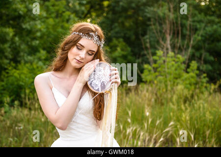 young redheaded girl smiling, Girl holding guardian, beautiful redheaded young girl, Girl holding dreamcatcher Stock Photo