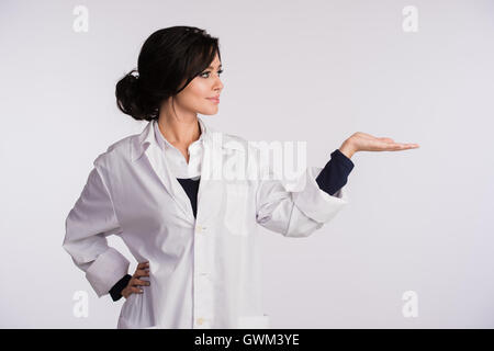 Pointing to blank copy space woman doctor nurse over white background Stock Photo