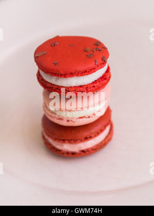 Red velvet, rose and raspberry macarons arranged in a pile. Stock Photo