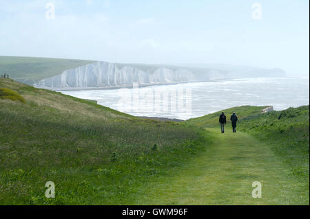 Two ramblers walking along the Seven Sisters, East Sussex, UK Stock Photo