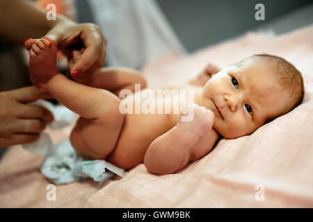 Parent changing beautiful newborn's diapers Stock Photo