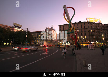 L'Ago e filo sculpture from a distance and traffic in Cadorna Station by night, Milan, Italy Stock Photo