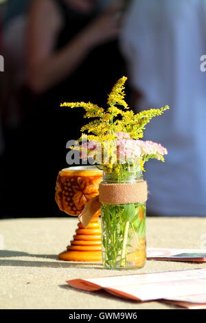 Bouquet of yellow and pink wildflowers in glass. Stock Photo