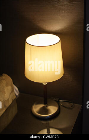 lamp on the nightstand in the bedroom next to the bed Stock Photo