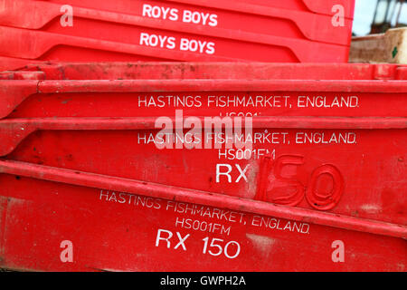 Stack of red plastic fish crates in fishing port, Hastings, East Sussex, England Stock Photo