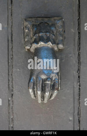 Antique metal door knocker shaped like a hand on old door in Toulouse, France, closeup. Stock Photo