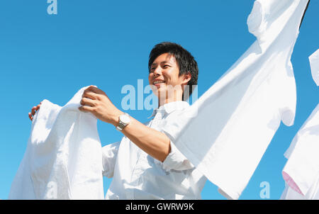 Young Japanese man doing laundry Stock Photo