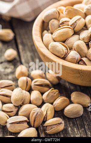 The pistachio nuts on old wooden table. Stock Photo