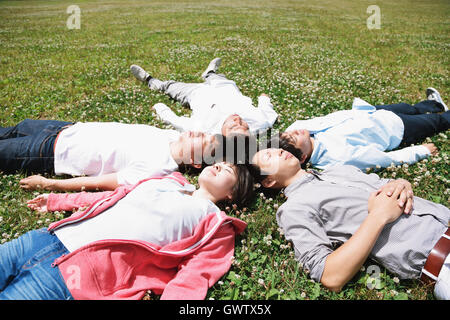 Group of young Japanese friends laying on grass Stock Photo